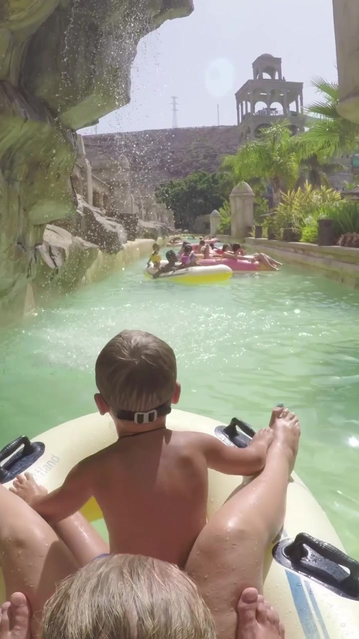 Barn med mor glæder sig over en tur i lazy river i vandland