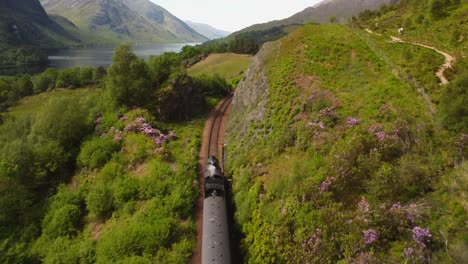 scotland steam train drone following shot reveal of converging mountains in distance