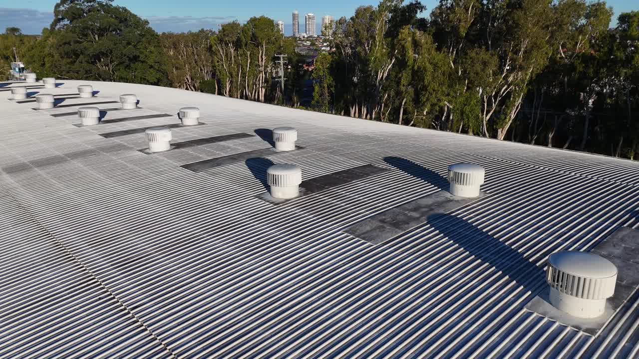 Aerial view of rooftop ventilation fans spinning under clear skies, highlighting industrial design and functionality in Gold Coast, Australia