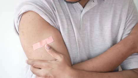 person with bandage on arm after vaccination