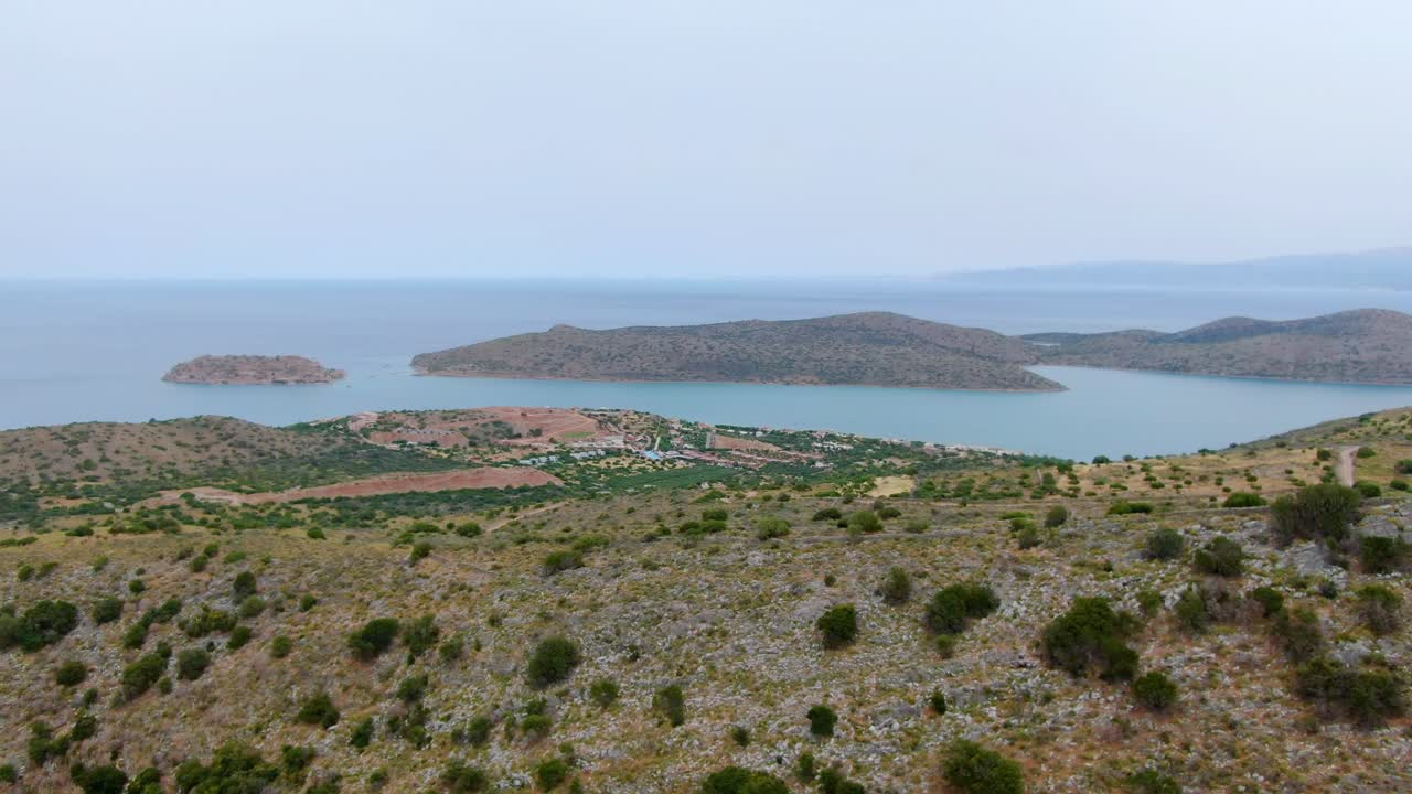 Barren dry Mediterranean coastal landscape with small islands in the shallow fog. Aerial panoramic drone shot