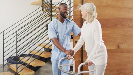 young african american male nurse assists senior caucasian woman at home