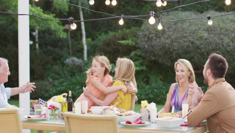 Kids-hugging-their-grandmother-while-having-lunch-outdoors