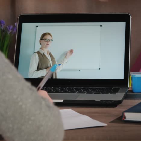 la niña aprende en casa en línea con su computadora portátil mientras su maestra da la lección en la pantalla 1