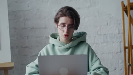 mujer joven trabajando en una computadora portátil