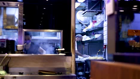 chefs cooking in a bustling hong kong kitchen