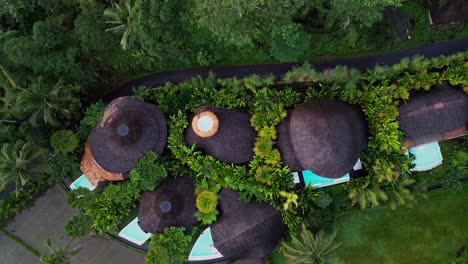aerial view over bali reveals luxury bamboo villas with serene pools hidden among tropical greenery where guests enjoy privacy comfort and a deep connection to nature.
