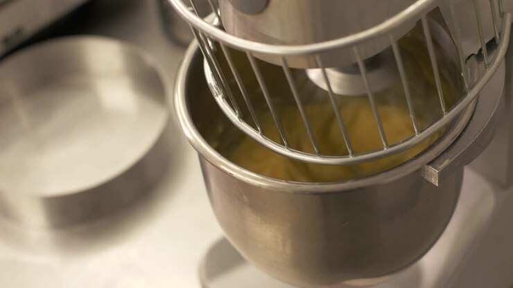 Impastatrice automatica che mescola ingredienti e impasta la pasta in un panificio, primo piano
