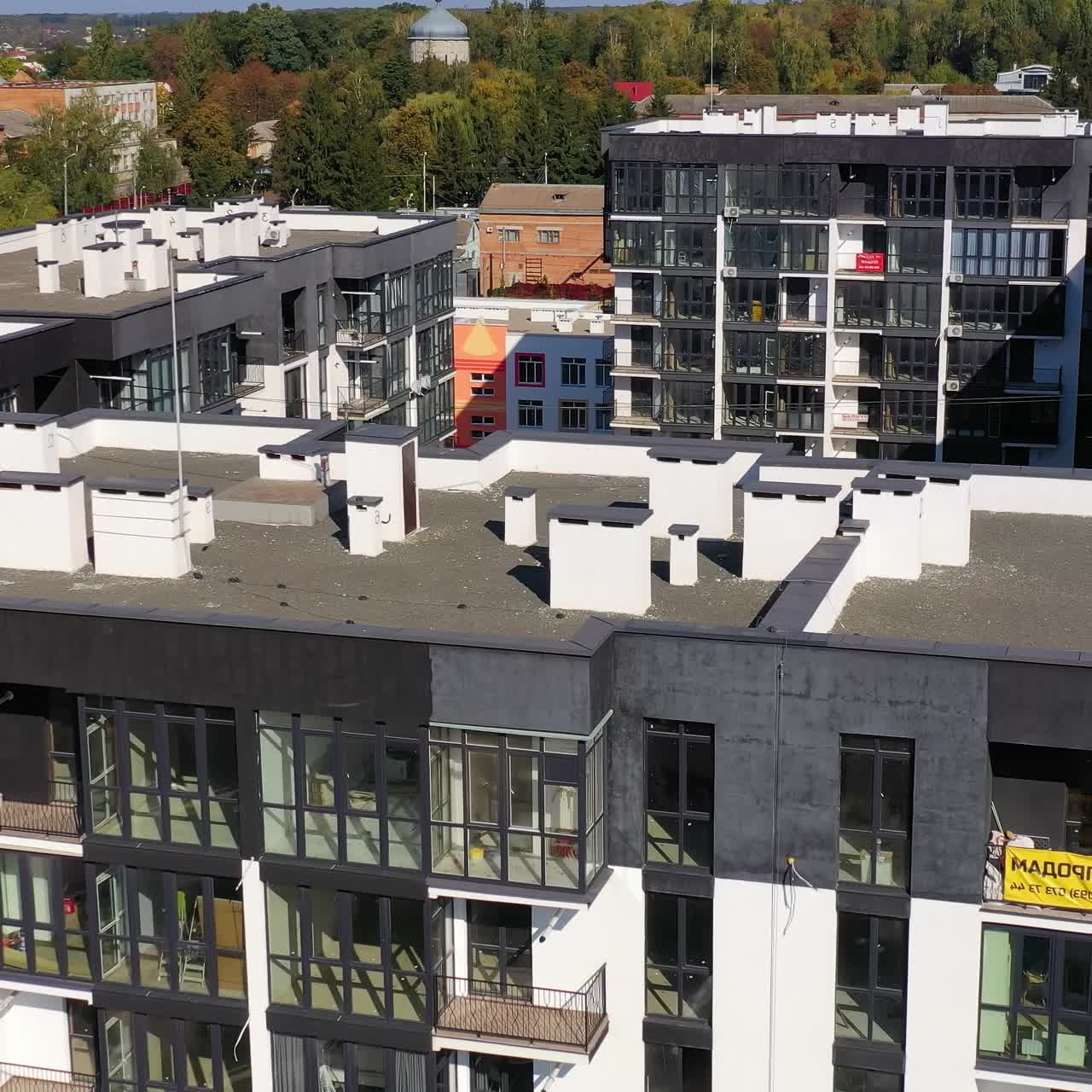 New architecture in the city. High-raise apartment buildings near the road. Modern design of multistorey building. Drone flight