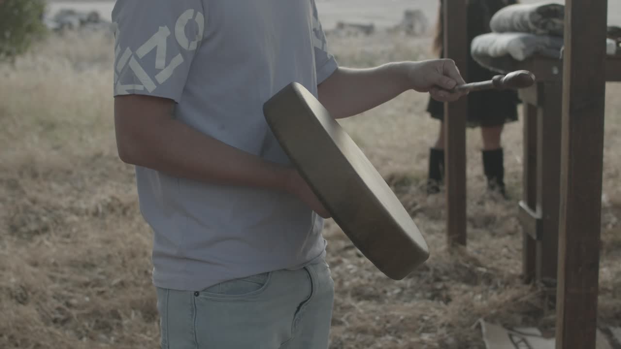 hombre nativo americano tocando el tambor lentamente para una ceremonia al aire libre