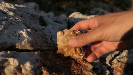 Holding-mineral-rock-in-nature,-calcite-crystal-stone-in-natural-environment