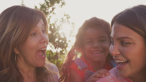 Familia-Hispana-Multigeneracional-Femenina-Relajándose-Juntas-En-El-Jardín-De-Casa