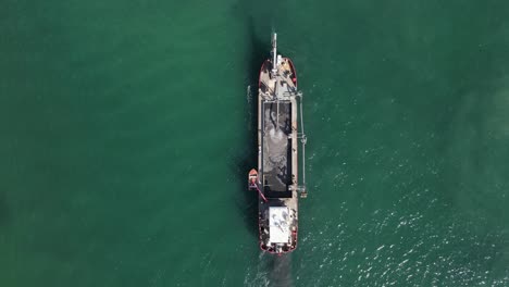 a large industrial dredging vessel sits in a shipping channel pumping tons of sand for a city rejuvenation project