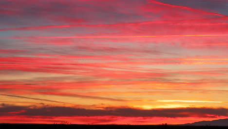 Puesta-De-Sol-De-Fuego-Impresionante-Con-Luz-Roja,-Rosa-Y-Naranja-Vibrante-En-Nubes-Tenues