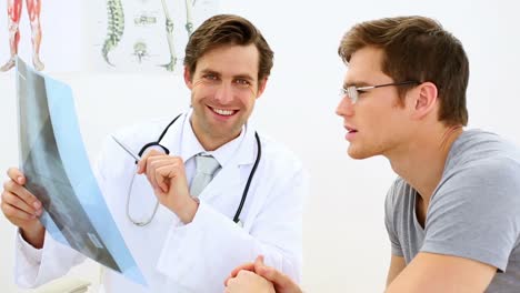 joven médico discutiendo rayos x con su paciente