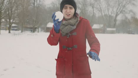 lady wearing red winter clothes holds and shows snowball on hand - handheld, medium shot