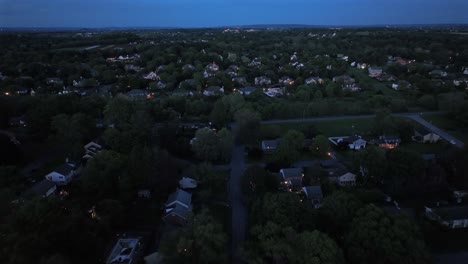 aerial birds eye shot of american housing area with real estate homes with green trees at dusk. wide shot. quiet suburb city of united states. panorama view. cozy atmosphere in residential area.