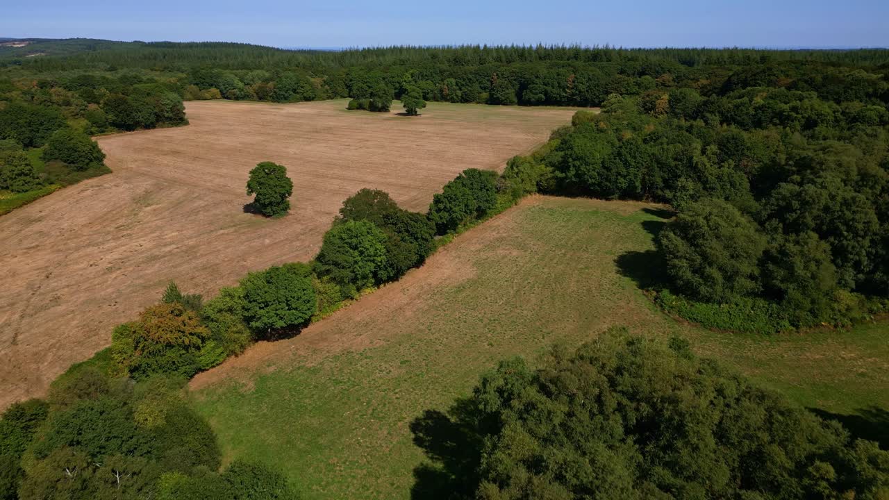 Rural landscape in Mayenne, lush green forest, France. Aerial drone forward