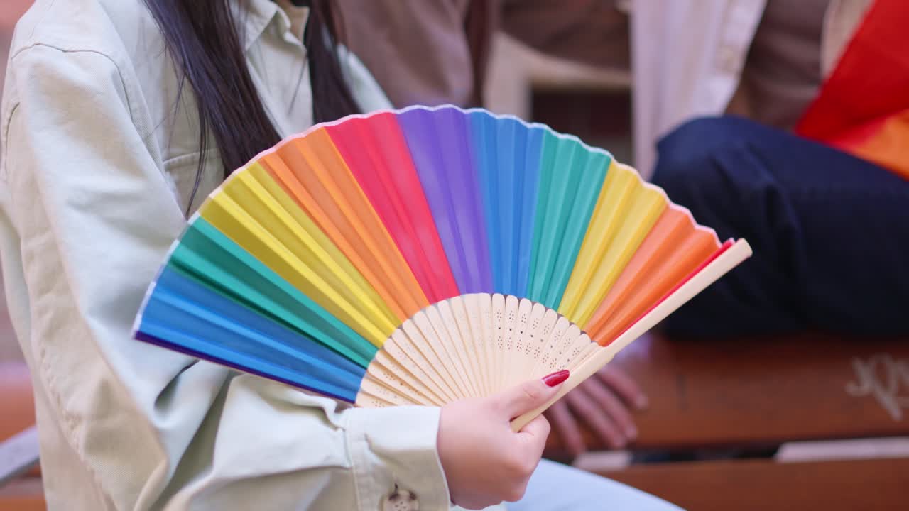 บุคคลถือพัดสีรุ้งสดใส