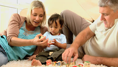 Doting-parents-and-child-playing-with-alphabet-blocks