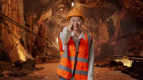 smiling woman engineer pointing in a tunnel