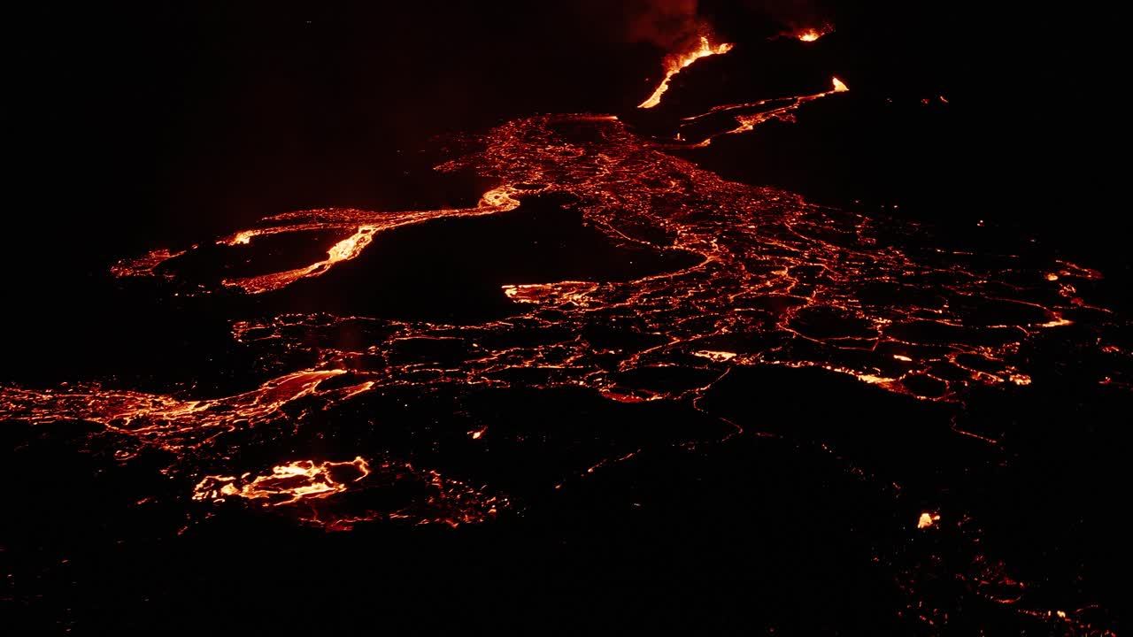 Campo lavico islandese con magma fuso che scorre come fiumi su superficie scura di notte