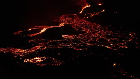 iceland lava field with molten magma flowing as rivers on dark surface at night