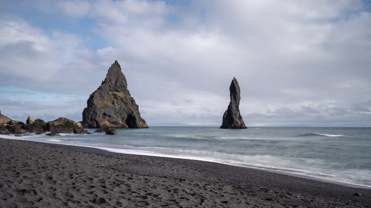 Reynisfjara Black Sand Beach, Vik, Iceland, Time Lapse of Clouds and Sea WIth Acute Rock Formations