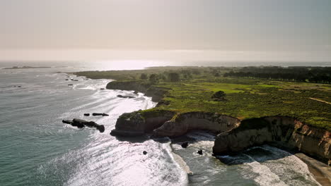 Año-Nuevo-Parque-Estatal-California-Antena-V1-Flyover-Cove-Beach-Capturando-La-Brillante-Luz-Del-Sol-Dorada-Brillando-En-El-Agua-Del-Mar-Y-El-Paisaje-De-Acantilados-Rocosos-Oceánicos---Filmada-Con-Mavic-3-Cine---Mayo-De-2022