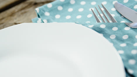 white plate with cutlery and napkin on table