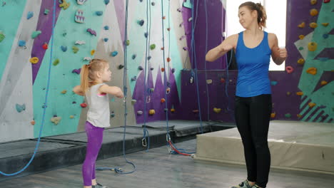 mother and daughter exercising in a climbing gym