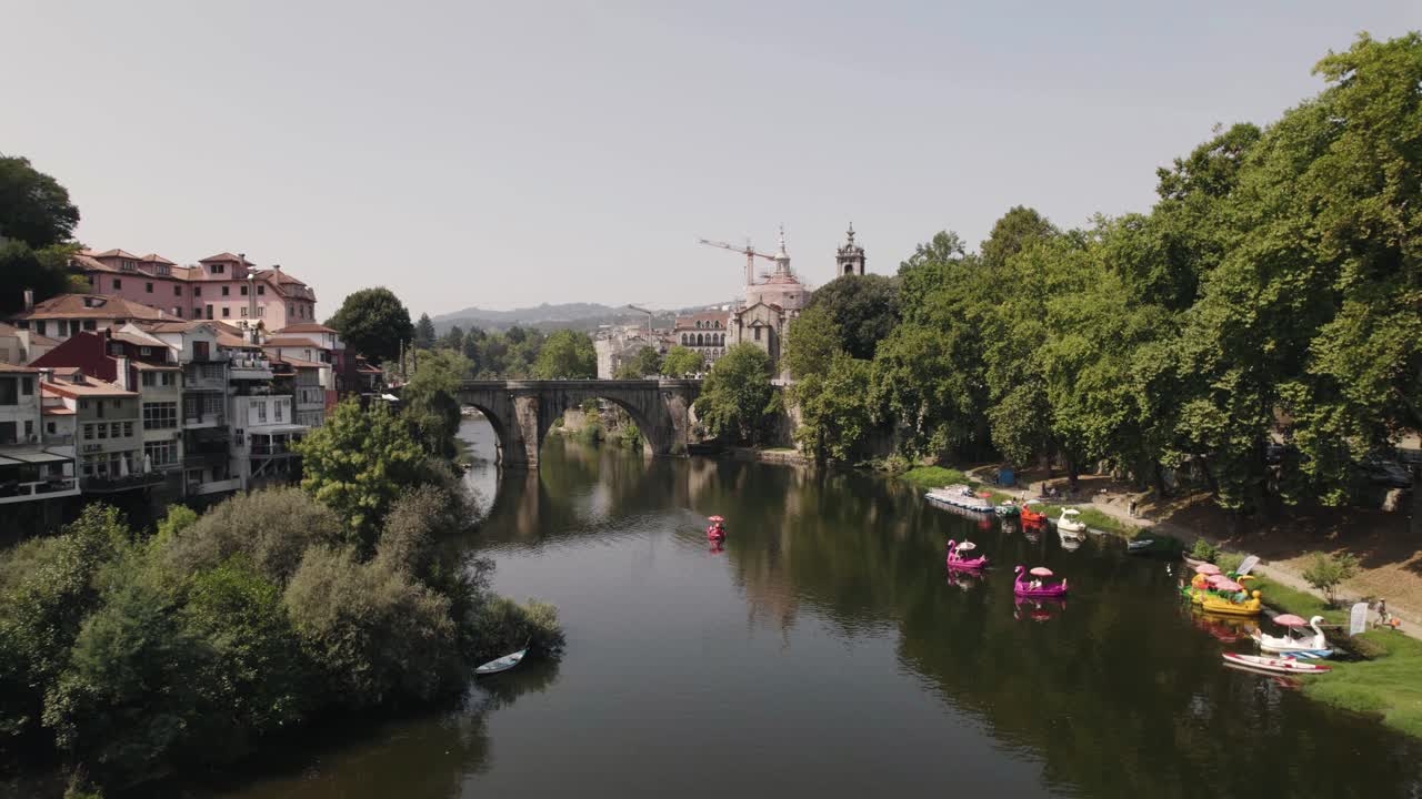 Skyline della città di Amarante con antico ponte in pietra e molte moderne barche a forma di animale nell'acqua del fiume, vista aerea