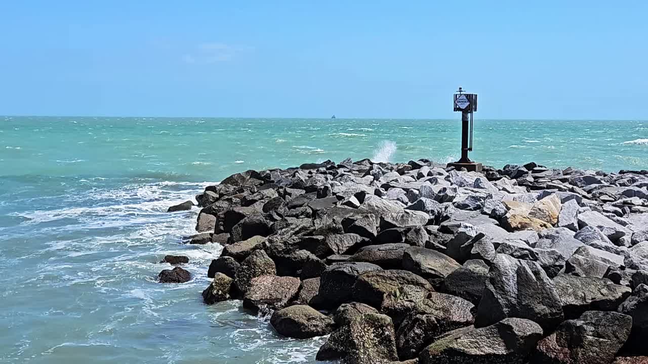 vista estática de las olas chocando contra la pared de roca cerca de la playa en cocoa beach, florida