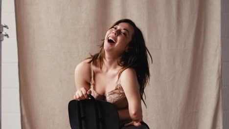 studio shot of confident woman with prosthetic limb in underwear promoting body positivity sitting on chair