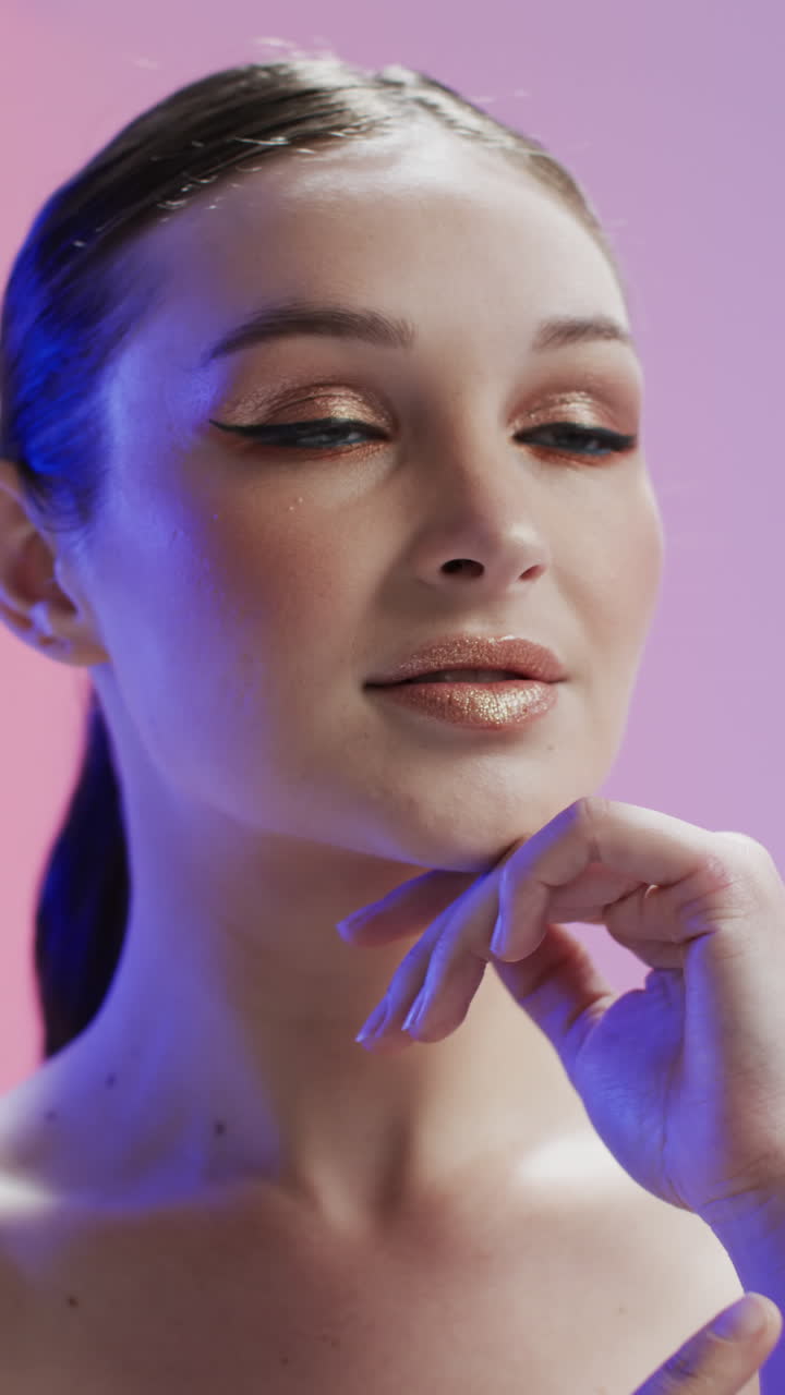 Video verticale di donna caucasica con capelli castani e trucco che si tocca il viso, spazio per la copia, rallentatore