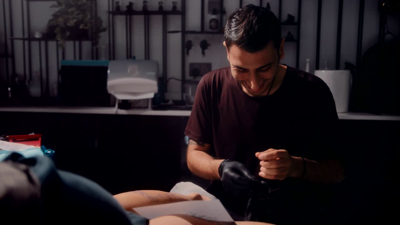 행복한 문신 마스터가 문신하기 전에 장갑을 착용하는 고객