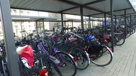 fast camera movement behind parked bycicles under roof in germany