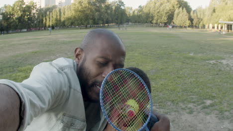 Father-and-son-taking-selfie-in-park,-having-fun-together.