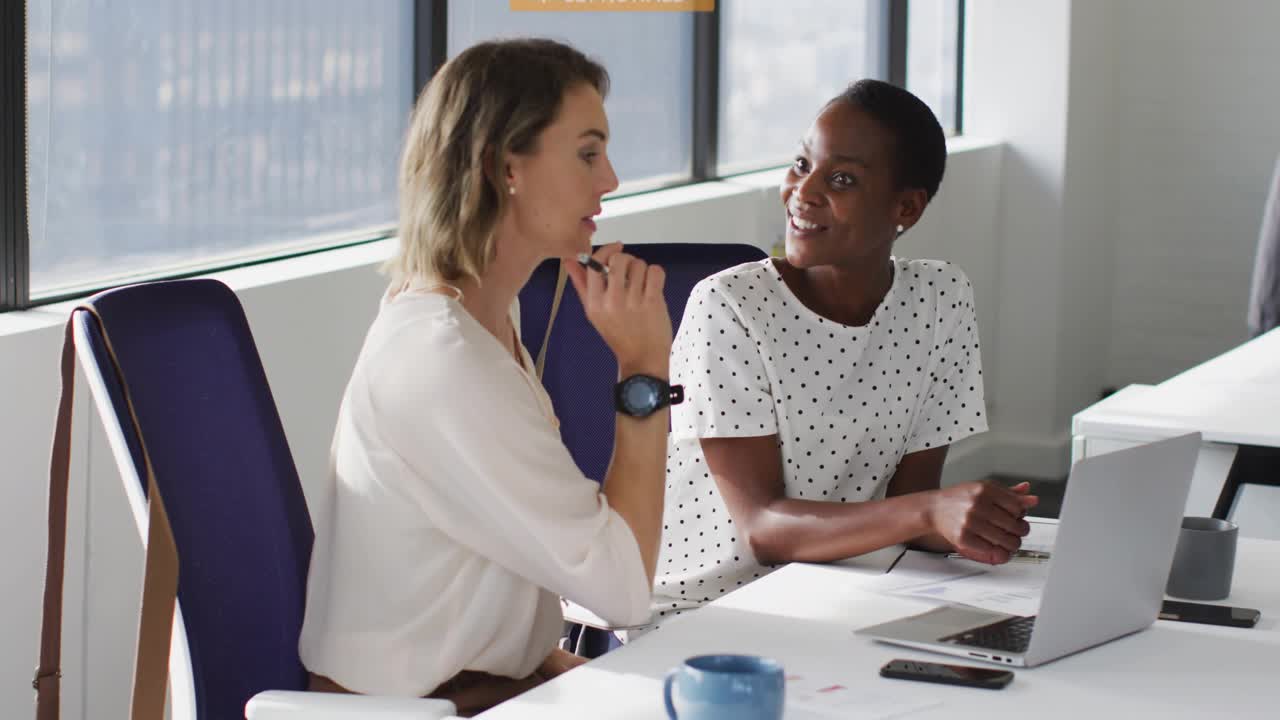 Marketing duo, lead explaining, peer tapping laptop, causing notifications appearing, receding
