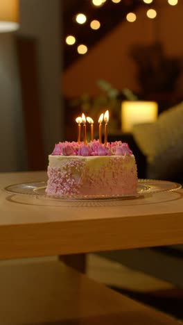 Vertical-Video-Of-Party-Celebration-Cake-For-Birthday-Decorated-With-Icing-And-Candles-On-Table-At-Home