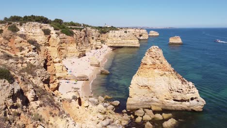 Vista-Aérea-De-Drones-De-La-Playa-De-Marinha-En-Algarve,-Sur-De-Portugal---Costa,-Acantilados,-Turistas-Y-Barco