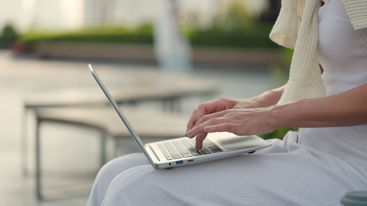 Woman Typing on Laptop Outdoors
