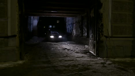 nighttime snowy alley with car