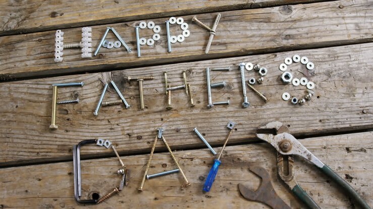 Happy fathers day text with various work tool arranged on wooden plank
