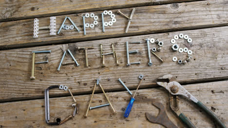 Happy-fathers-day-text-with-various-work-tool-arranged-on-wooden-plank