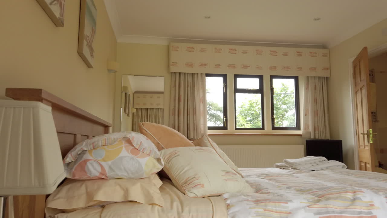 실내 욕실이 있는 현대적인 게스트 침실의 왼쪽에서 오른쪽 팬