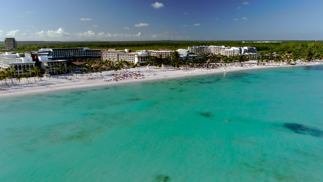 Bogenförmige Luftaufnahme eines großen Luxusresorts an einem weißen Sandstrand in der Dominikanischen Republik.