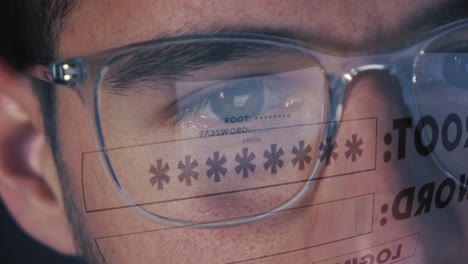 man in front of a computer screen logs into account with username and password that is reflected on his glasses