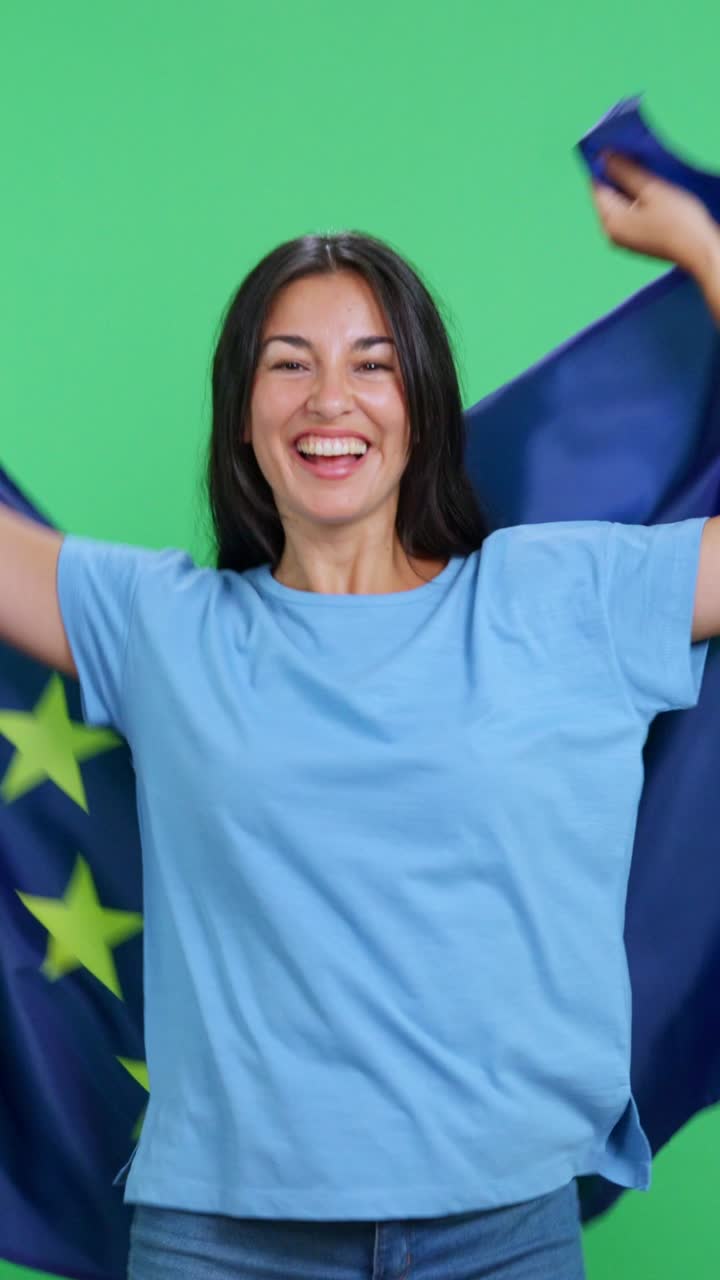 Allegra donna patriottica che si avvolge nella bandiera dell'Unione Europea