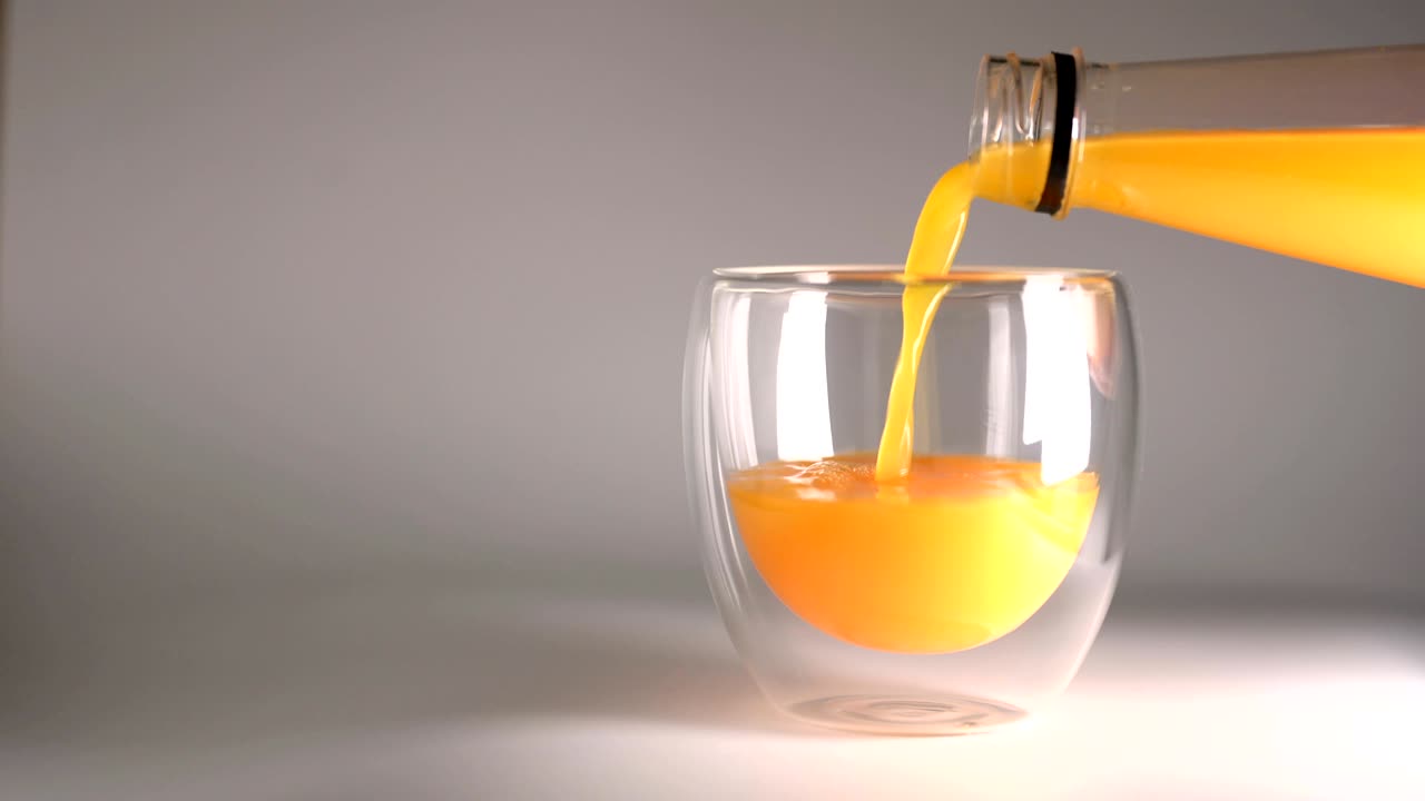 Cinemagraph in loop: versamento di succo d'arancia in bottiglia